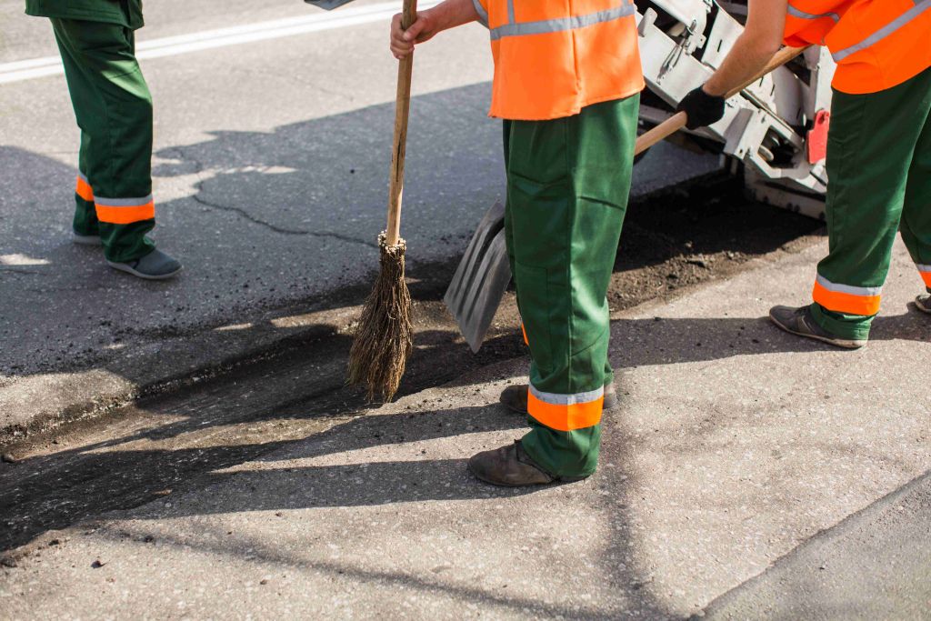 Working paver sweeps debris out of the hole