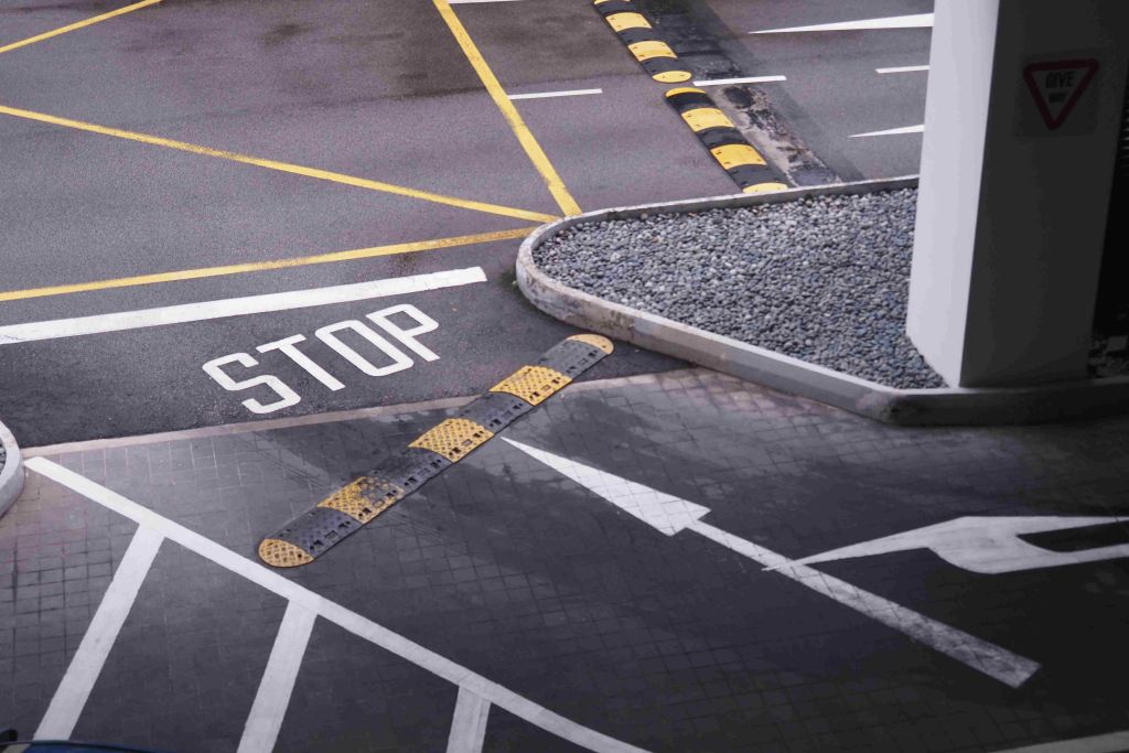 Stop sign in parking lot with marked lanes and curbs