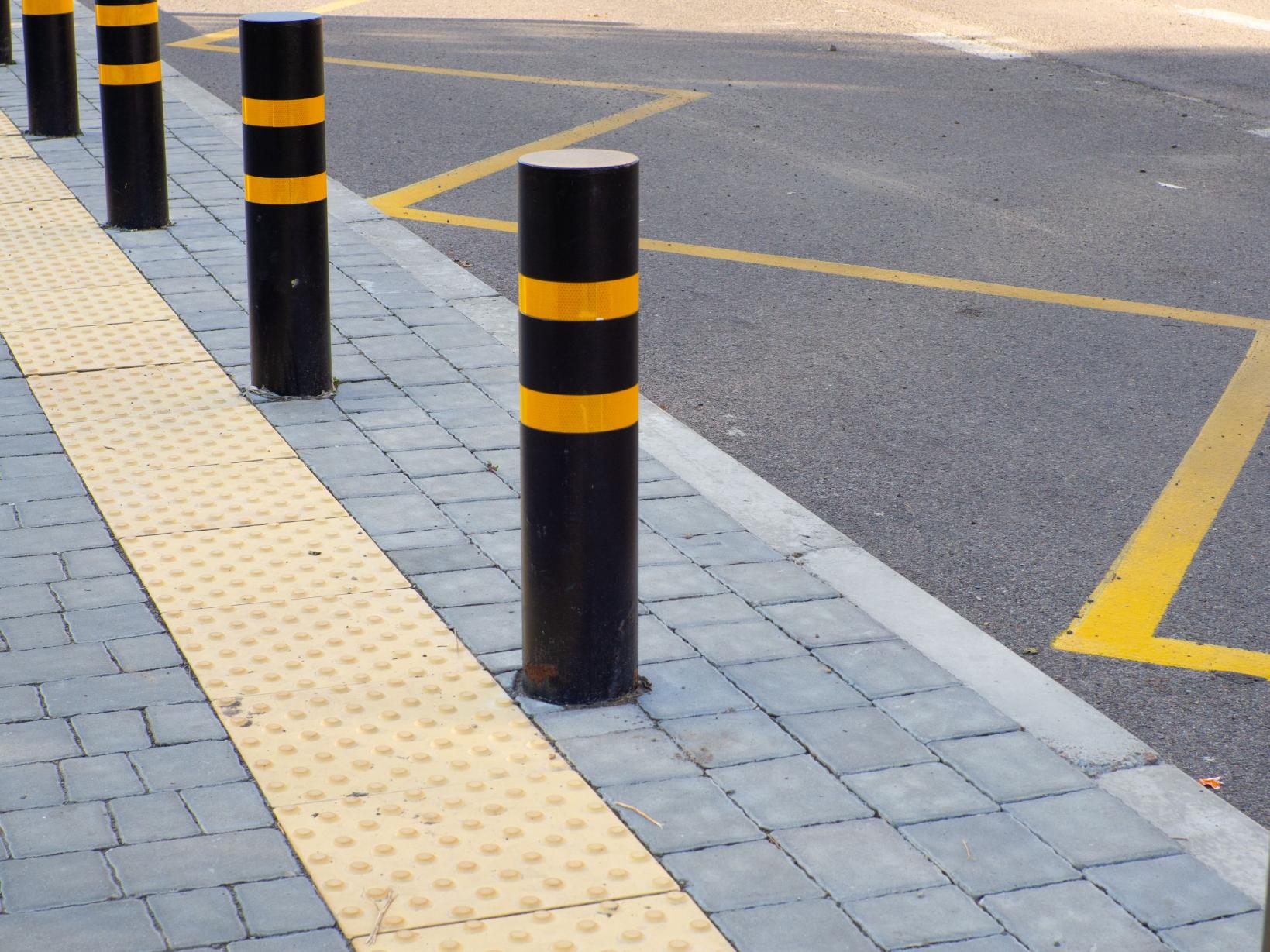 Yellow pavement for the blind on the floor on the bus stop