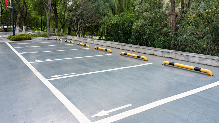 Outdoor parking lot with white lines and yellow barriers