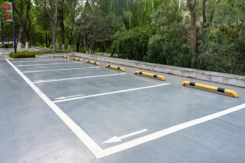 Outdoor parking lot with white lines and yellow barriers